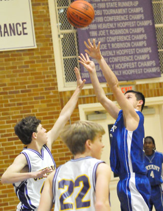 Bryant's Clay Ingold attempts a shot over Catholic's Joe Meyers. (Photo by Kevin Nagle)