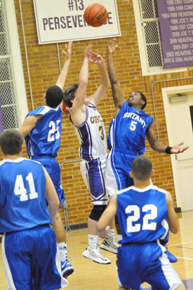 Jaelynn Jones (25) and Kris Croom (5) battled with Catholic's Ethan Elia for a loose ball. (Photo by Kevin Nagle)