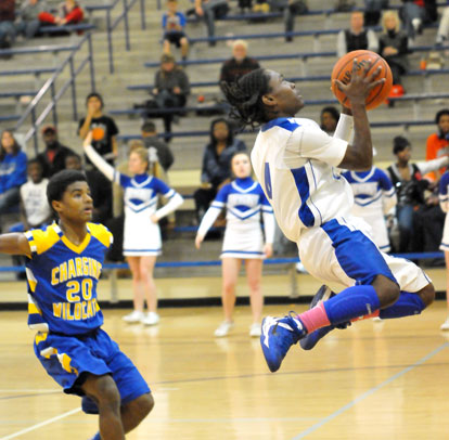 Simeon Watson drives goes up for a shot in front of North Little Rock's Rokar Williams. (Photo by Kevin Nagle)