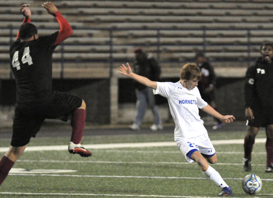 Corey Ballew lines up a shot as a Pine Bluff player tries to leap into the path to the goal. (Photo by Kevin Nagle)