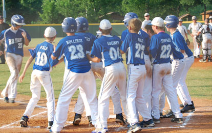 Jacob Coppock is greeted by his teammates after belting a grand slam in the championship game.