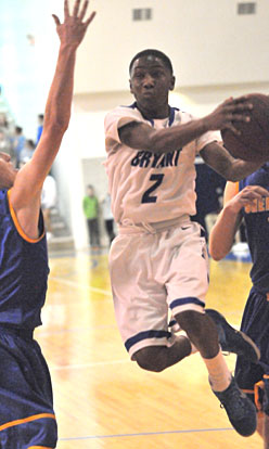 Desmond Duckworth splits a pair of Sheridan defenders on a drive to the basket. (Photo by Kevin Nagle)