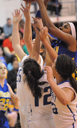 Sheridan's Kadesha Cooper, right, plays through Bryant's Erica Smith (25), Maddie Baxter (12) and Aubree Allen (23) to get to a rebound. (Photo by Kevin Nagle)