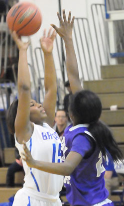 Jayla Anderson (15) reaches high to get a shot away. (Photo by Kevin Nagle)