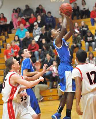 Marvin Moody takes a shot inside in front of teammate Kyle Sahr and Cabot's Jarrod Barnes (12). (Photo by Kevin Nagle)