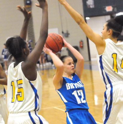 Bryant's Sarah Kennedy (12) is trapped by North Little Rock's inside tandem of Yominis Morris (15) and Karissa Jones. (Photo by Kevin Nagle)