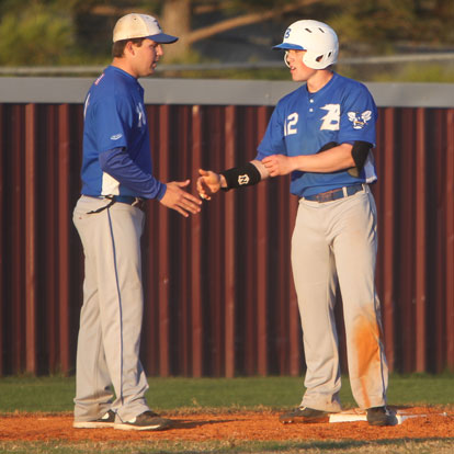 Bryant's Trevor Ezell is congratulated by third base coach Travis Queck after Ezell stole the base. (Photo by Rick Nation)