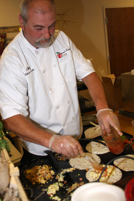 Chef Daryn Cole, with Dinner's Ready Catering, adds salsa to a custom ordered breakfast burrito. (Photo by Rick Nation)