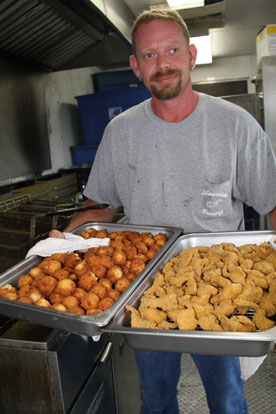 Scott Gossett from Riverside Grocery serves up catfish and hush puppies. (Photo by Rick Nation)