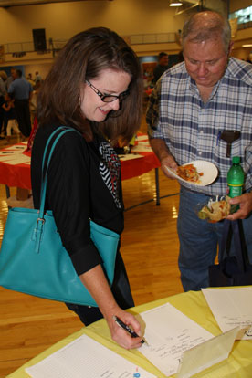 Brook Tropp discusses her silent auction bid with Tom Miller. (Photo by Rick Nation)