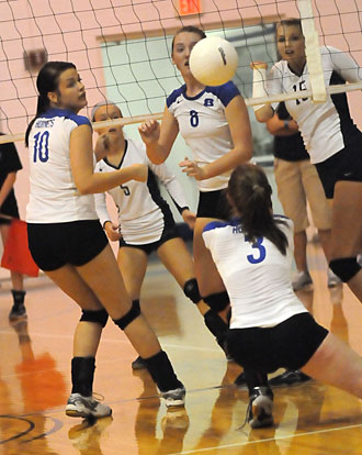 Nikki Clay (3) digs up a hit behind Rylee Phillips (10) and Brittney Sahlmann. (Photo by Kevin Nagle)