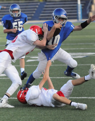 Quarterback Jesse Windemaker fights to fend off two Cabot North tacklers after being sprung loose by the block of Jakob Neel (55). (Photo by Kevin Nagle)