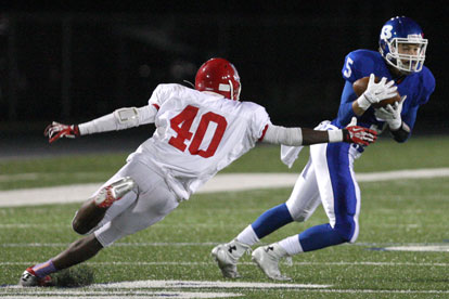 Sophomore Austin Kelly (5) makes a catch and cuts back past McClellan's Miguel Evans (40). (Photo by Rick Nation)