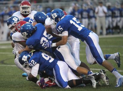 Mario Waits (92), Devon Alpe (25), Ben Bruick (15) and Hunter Fugitt (33) pile up a McClellan ballcarrier. (Photo by Rick Nation)