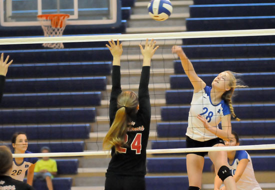 Reagan Blend (28) tries to get a hit over a Russellville blocker as Kasey Ward (26) and Rylee Phillips (10) prepared for the return. (Photo by Kevin Nagle)