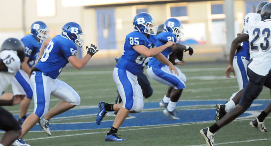 Dagin Carden (85), Cole Chapman (58) and Daniel Coppock (70) look to make room for Cameron Coleman (21) to run. (Photo by Kevin Nagle)