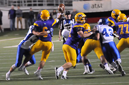 Hunter Fugitt (33) hits Catholic quarterback Andre Sale as he gets a pass away. Ryan Hall (43) and Mario Waits (92) add to the rush. (Photo by Kevin Nagle)