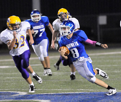 Quarterback Michael Jones (8) looks for running room after getting a block from Josh Wyllia (77). (Photo by Kevin Nagle)