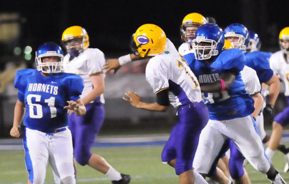 James McClendon (82) lowers the boom on Catholic quarterback Nathan Page as Ryan Harris (61) contains. (Photo by Kevin Nagle)