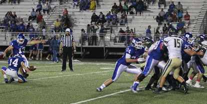 Alex Denker kicks one of his three field goals out of the hold by Madison Schrader. (Photo by Rick Nation)