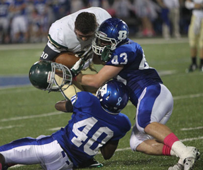 Ryan Hall (43) and Jordan McDonald (40) haul down Alma running back Landon Brigance. (Photo by Rick Nation)