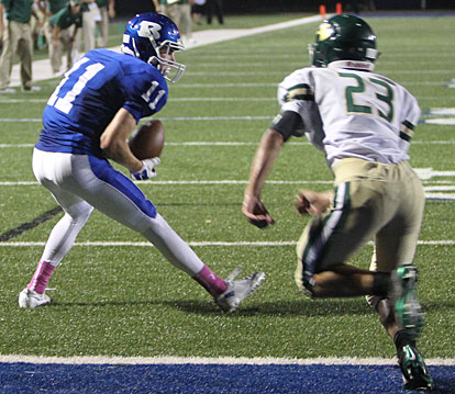 Evan Lee (11) latches onto a pass as Alma's Josh Parker (23) moves in for the tackle. (Photo by Rick Nation)