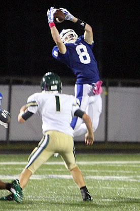 Aaron Orender (8) goes high to grab a pass over Alma's Heath Friddle (1). (Photo by Rick Nation)