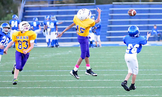 Tristan Hays (26) prepares to catch a pass over a pair of Horace Mann defenders. (Photo by Kevin Nagle)