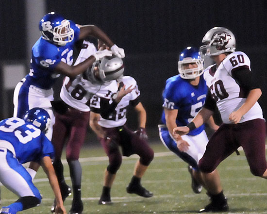 Madre Dixon (93), Marvin Moody (86) and Dany Murillo (50) converge at the Benton quarterback. (Photo by Kevin Nagle)