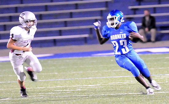 Bryant's Isaiah Ash (23) looks to evade a Benton defender. (Photo by Kevin Nagle)