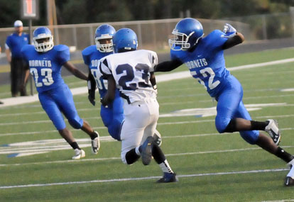 Antonio Todd (52) reaches out for Conway Blue's Rickey Fuller (23) on a kickoff return as help arrives including Isaiah Ash (23). (Photo by Kevin Nagle)