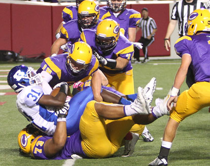 Sevante Turner (31) falls into the end zone in the arms of Catholic's Luc Bequette. (Photo by Rick Nation)