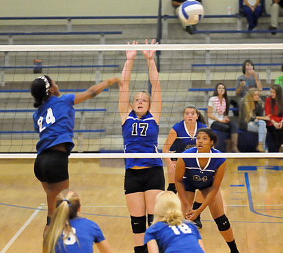 Tori Allen (17) attempts a block as Raven Loveless (24, to right), and Ashlyn Lee (25) position themselves for a dig. (Photo by Kevin Nagle)