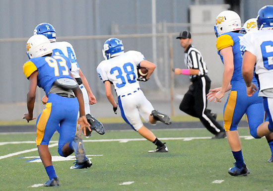 Dustin Bishop heads toward the end zone after scooping up a loose ball off a blocked punt. Tanner Austin (84) provides an escort. (Photo by Kevin Nagle)