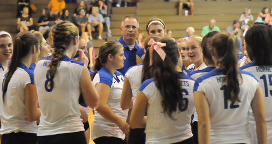 The Lady Hornets huddle up with Coach Lawrence Jefferson during a timeout. (Photo by Kevin Nagle)