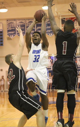 Lowell Washington (32) splits a pair of Benton defenders, Westin Riddick (32) and Ketiron Jones (1) on the way to the hoop. (Photo by Rick Nation)