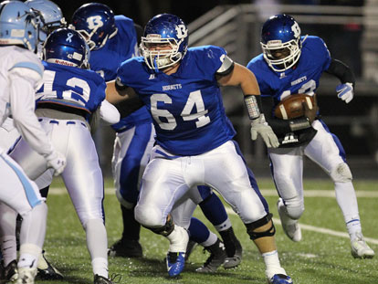 Kylon Boyle followed Caleb McElyea (64) and Demaja Price (42) around the left side. (Photo by Rick Nation)