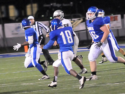 James Polite (18) returns a first-quarter interception with an escort of teammates. (Photo by Kevin Nagle)