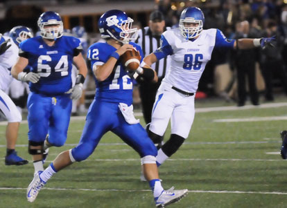 Brandan Warner looks to throw as teammate Caleb McElyea (64) hustles out to try to give him some time. (Photo by Kevin Nagle)