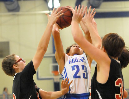 Alex Blair (23) tries to shoot as a pair of Russellville defenders converge. (Photo by Kevin Nagle)