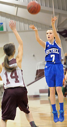 Ashlyn Thompson (7) fires up a shot over Benton's A.K. Smith. (Photo by Kevin Nagle)