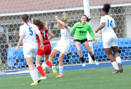 Bryant keeper Maddie Hawkins watches her teammates Whitney Brown, Jad'n Nichols (14) and Kendall Selig (5) try to work the ball out of the defensive end. (Photo by Kevin Nagle)