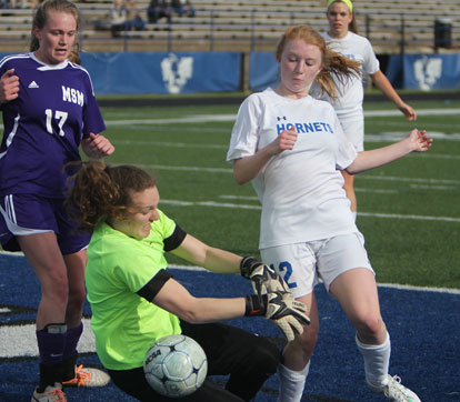 Caroline Campbell (12) fights to get a shot past the Mount St. Mary goalkeeper. (Photo by Rick Nation)