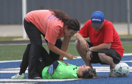 Lady Hornets head coach Julie Long and athletic trainer Brent Phillips attend to goalkeeper Maddie Hawkins after she was shaken up during Friday's Class 7A State Tournament game against Fort Smith Southside at Bryant Stadium. (Photo by Rick Nation)
