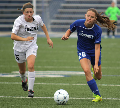 Bryant's Jessica Butler (26) and Bentonville's Anna Passmore (5) sprint after a loose ball. (Photo by Kenzi Brenton)