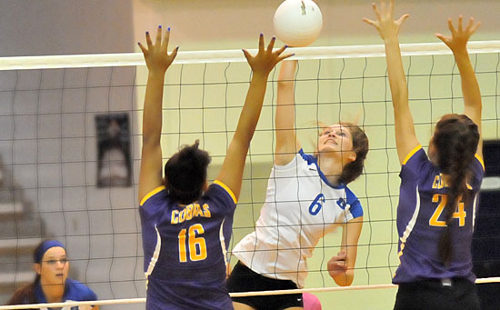 Allie Anderson goes high on a hit during her 21-kill performance Tuesday night. Teammate Shayla McKissock, left, gets ready for a return. (Photo by Kevin Nagle)