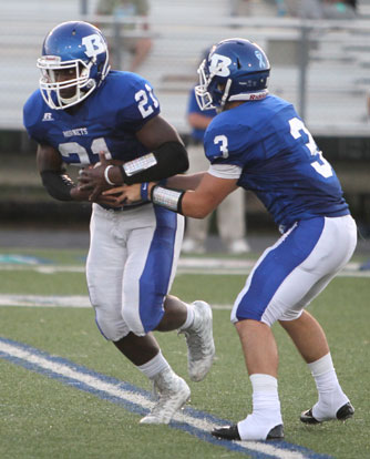 Cameron Coleman (21) takes a handoff from quarterback Gunnar Burks. (Photo by Rick Nation)