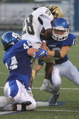 Bryant's Devon Howard (44) and Michael Jones (12) sandwich Pulaski Academy running back Jaren Watkins. (Photo by Rick Nation)