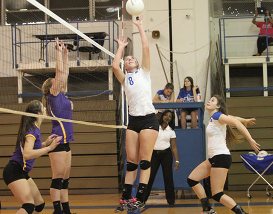 Britney Sahlmann (8) goes high for a tip during Tuesday's season-opening win. (Photo by Rick Nation)