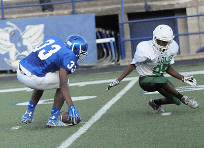 Ahmad Adams (33) picks up a fumbled pitch that got past Forest Heights running back Jarmall Lovelace. (Photo by Kevin Nagle)